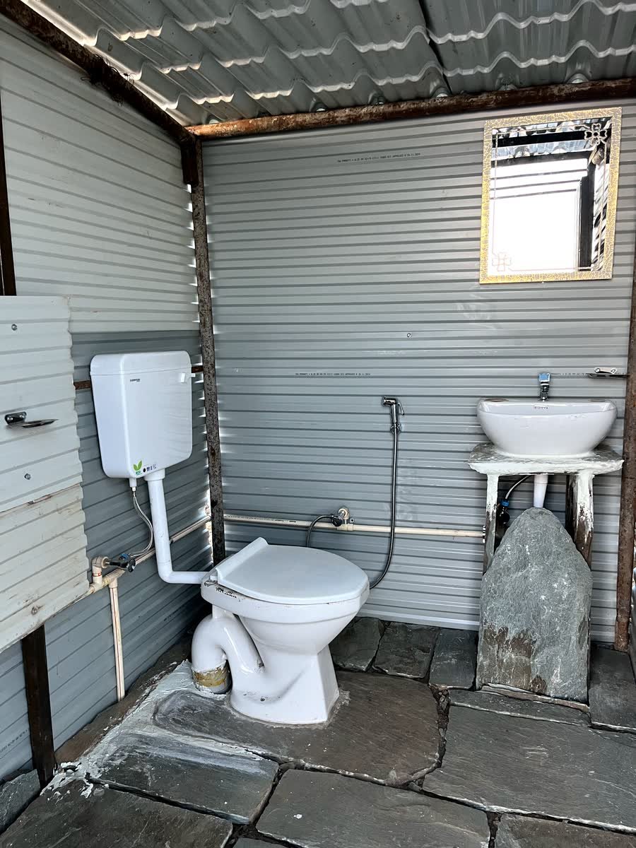 Washroom at Thatharana Trek with a wash basin, geyser and tiled stone floor